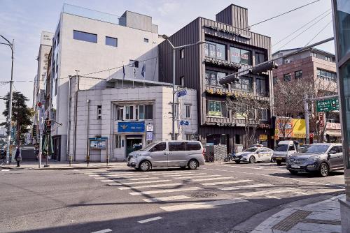a busy city street with cars parked in front of buildings at Life in Euljiro in Seoul