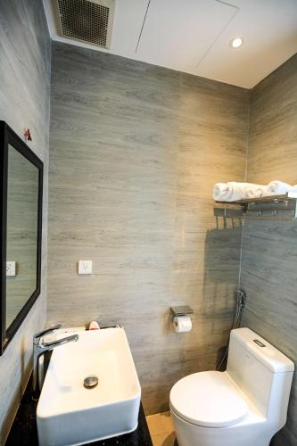 a bathroom with a white toilet and a sink at The Bok Hotel Grand World - by GoGo Phú Quốc in Phu Quoc