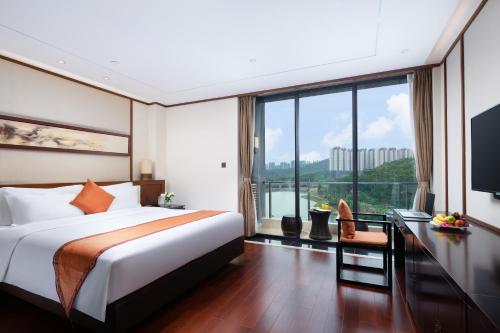 a hotel room with a bed and a large window at The Yun Resort QingYuan in Qingyuan