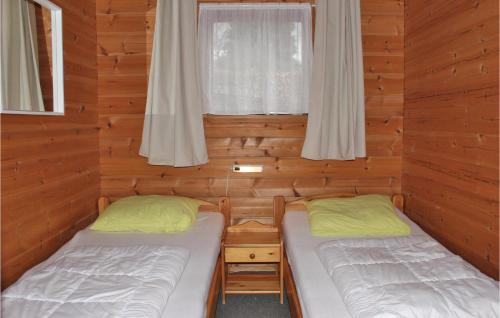 two beds in a log cabin with a window at Nice Home In Hulshorst With Wifi in Hulshorst