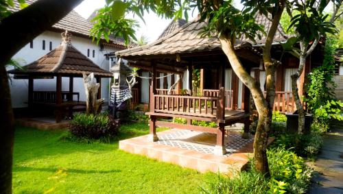 un banco frente a una casa con cenador en La Nusa Penida Homestay by BIJAK, en Nusa Penida