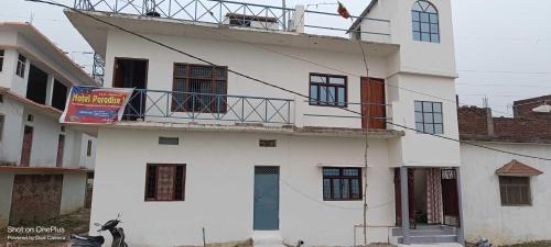 ein weißes Gebäude mit Balkon darüber in der Unterkunft SPOT ON Hotel Paradise Inn in Gorakhpur