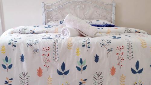 a bed with a white comforter with leaves on it at Sandakan Homestay in Sandakan