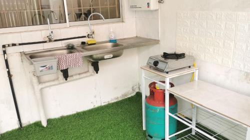 a kitchen with a sink and green grass at Sandakan Homestay in Sandakan