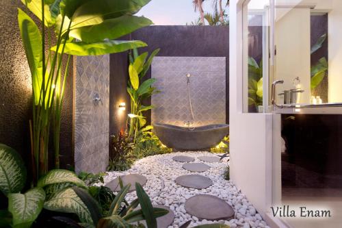 Villa Mia Seminyak - Boutique Villas في سمينياك: حمام مع حوض استحمام في حديقة