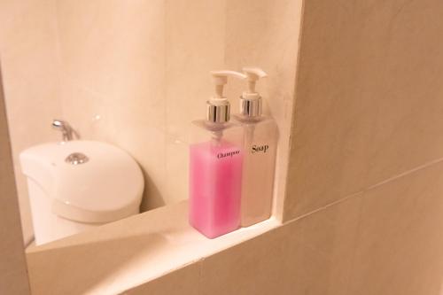 a couple of soap bottles sitting on a shelf in a bathroom at President Hotel Udonthani in Udon Thani