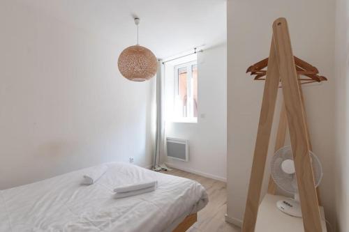 a white bedroom with a bed and a window at Cabana & Hypercentre Cosy in Roanne