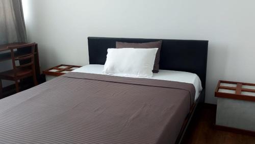 a bed with a black headboard and a white pillow at Jays Guest - Rajagiriya Colombo in Rajagiriya