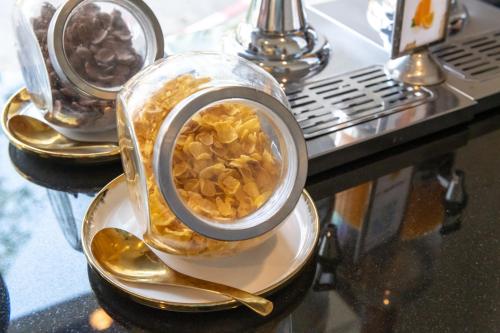 a container of food sitting on a table with spoons at President Hotel Udonthani in Udon Thani