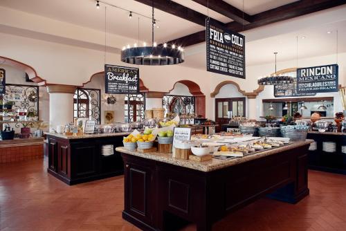 a restaurant with a buffet of food on a counter at The Club at Hacienda del Mar in Cabo San Lucas
