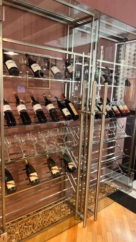 a display case filled with lots of bottles of wine at Hotel Dastan Aktobe in Aktobe