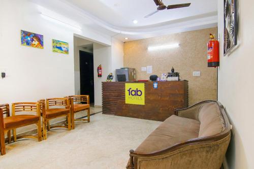 een woonkamer met een bank, stoelen en een aanrecht bij FabHotel Water Vibe in Gurgaon