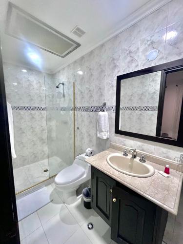a bathroom with a sink and a shower and a toilet at Hotel Ingenio Reina Isabel in Cali