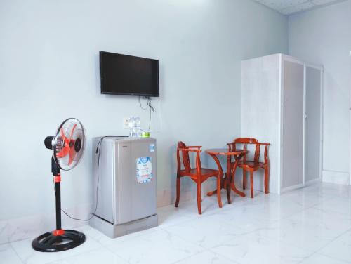 Zimmer mit einem Ventilator und einem Tisch mit Stühlen in der Unterkunft Nhà nghỉ Thành Lợi in Ấp Rạch Mẹo