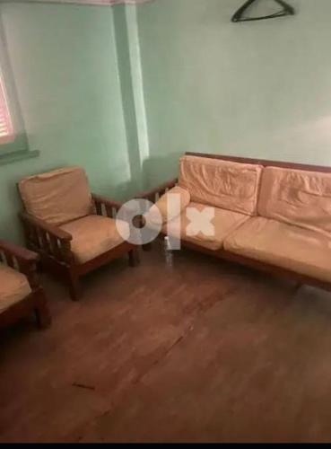 sala de estar con sofá y silla en المحله الكبرى en El-Mahalla El-Kubra