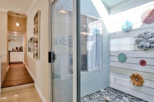 a walk in shower with a glass door in a room at Seabreeze-Modern Home w Outdoor Living&Near Beach in Huntington Beach