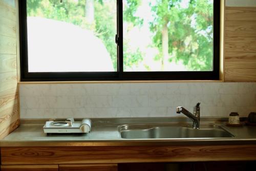 a kitchen sink with a window above it at スナッパーロック 屋久島 in Yakushima
