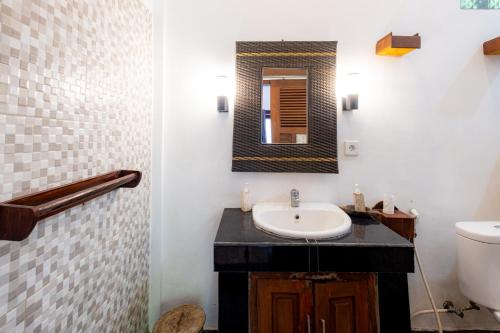 a bathroom with a sink and a mirror at Villa Kubu Arya by Supala in Ubud