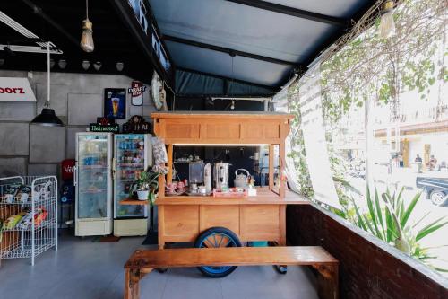 a food cart with a bench in front of a store at RedDoorz near Alun Alun Madiun in Madiun
