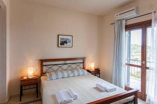 a bedroom with a large bed with two towels on it at Villa Seashell, Private Pool and Magnficent View in Ravdhoúkha