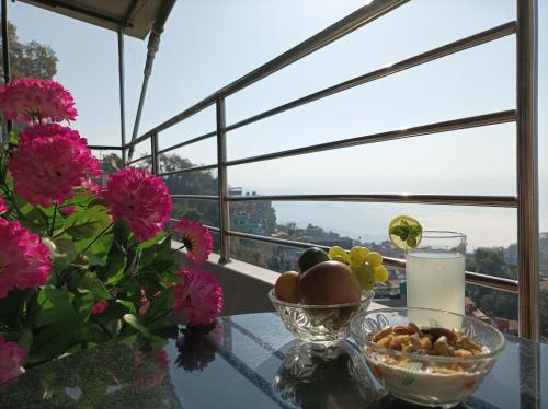 Tānsen的住宿－Natures Treat Homestay，玻璃桌,放着一碗食物和鲜花