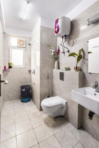 a bathroom with a toilet and a sink at Homlee-Super Luxury 4 BHK Apartment nr NOIDA EXPO in Noida
