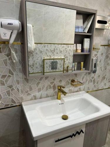 un bagno con lavandino e specchio di غرفة أنيقة ساحرة - الوصول ذاتي a Riyad
