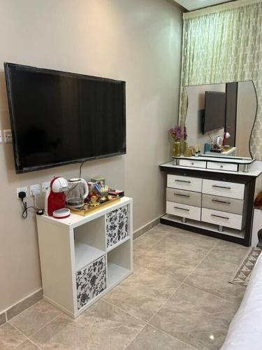 una camera da letto con una grande TV a schermo piatto sul muro di غرفة أنيقة ساحرة - الوصول ذاتي a Riyad