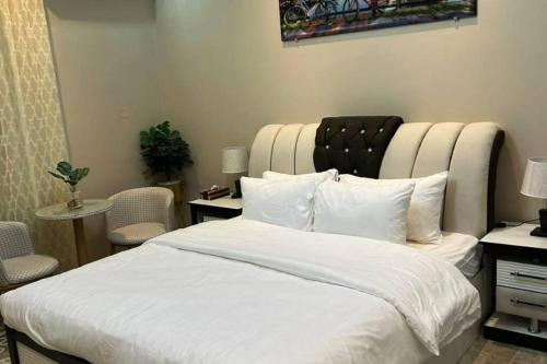 una camera da letto con un grande letto bianco con una grande testiera di غرفة أنيقة ساحرة - الوصول ذاتي a Riyad