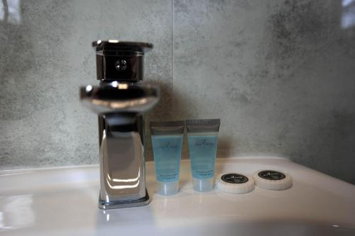 a bathroom sink with a faucet and two glasses at Hotel George in Nadarzyn