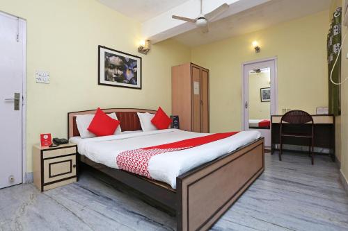 a bedroom with a large bed with red pillows at Kalighat in Ālīpur