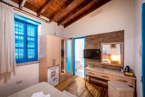 a room with a bed and a mirror and a television at Cypriot Swallow Boutique Hotel in North Nicosia