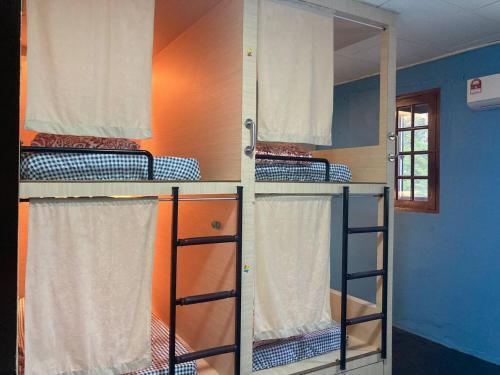 a room with three bunk beds in a room at Stop @Melaka Guesthouse in Melaka