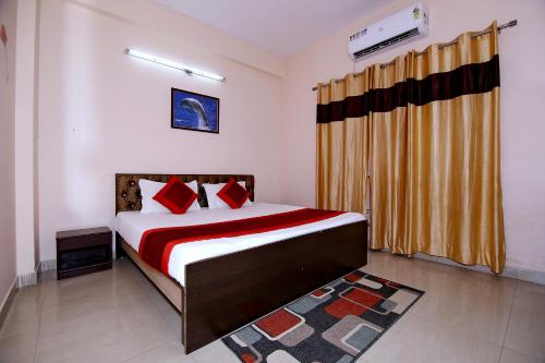 a bedroom with a bed with red pillows at OYO The Nest in Greater Noida