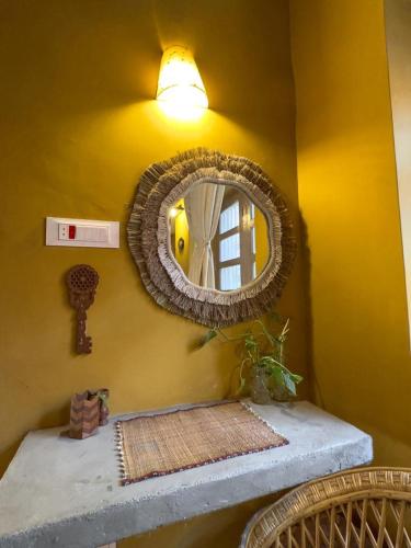 a mirror on a yellow wall with a shelf and a sink at The Melo pomelo courtyard. ( Right in between Thamel and basantapur durbar square) in Kathmandu