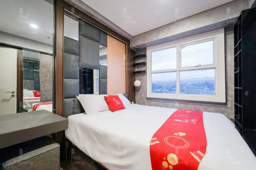 a bedroom with a large bed and a window at RedLiving Apartemen Parahyangan Residence - Anton Rooms in Bandung
