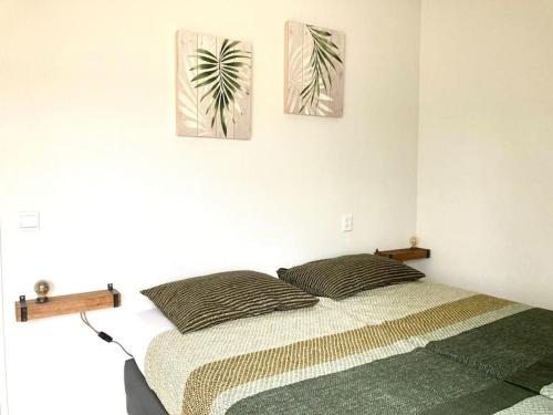 ein Schlafzimmer mit einem Bett und zwei Gemälden an der Wand in der Unterkunft Maralong Noordwijk in Noordwijk