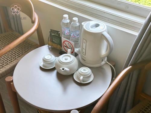 a table with a tea kettle and cups on it at Cherry Luxury Hotel in Da Lat