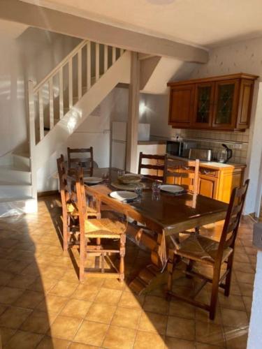 - une cuisine avec une table à manger et des chaises dans l'établissement Les Poissons Rouges, à Lanchères