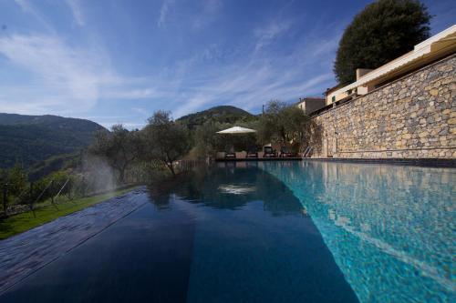 una grande piscina accanto a un muro di pietra di Miramare Apartments&Suites a La Spezia