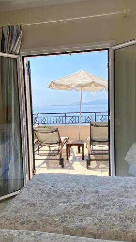 a bedroom with a view of a patio with an umbrella at Beach villa Aetos kaminaki Nissaki in Nisakion