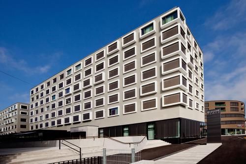 a large white building with a lot of windows at Vienna House by Wyndham zur Bleiche Schaffhausen in Schaffhausen