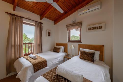 um quarto com 2 camas e uma janela em San Lameer Villa 2814 - 3 Bedroom Classic - 6 pax - San Lameer Rental Agency em Southbroom