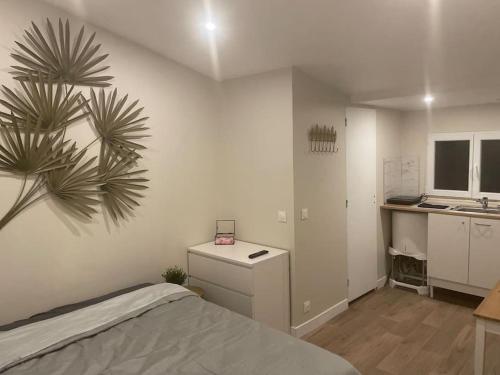 ein Schlafzimmer mit einem Bett und einem Schreibtisch sowie eine Küche in der Unterkunft Studio indépendant - CDG, Paris,Disney,Astérix in Arnouville-lès-Gonesse