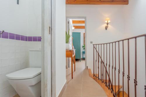 a bathroom with a toilet and a staircase at Ses Andrones 3 in Ciutadella