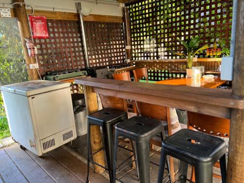 a bar with two stools and a table and a stove at XYL Holiday Inn in Caloundra