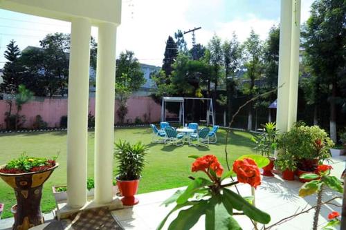 a patio with chairs and plants on a yard at Alaf Laila Guest House in Abbottābād