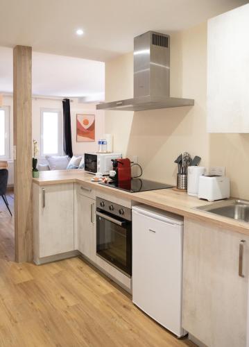 une cuisine avec un évier et une cuisinière four supérieur dans l'établissement Centre Ville - Cocon Des Bois - Gare, à Saverne