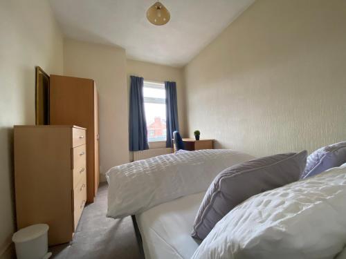 a bedroom with two beds and a dresser and a window at Nice Living Serviced Accommodations 5 in Coventry