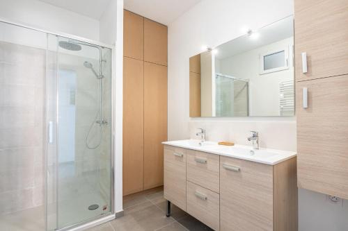 une salle de bain avec une douche, un lavabo et un miroir dans l'établissement Banc des Flandres, à Bray-Dunes